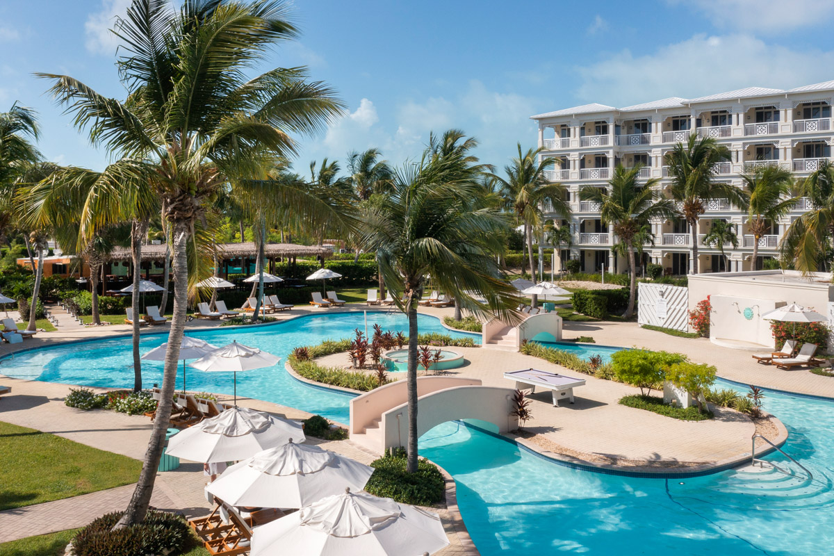 Lagoon-style pool surrounded by palm trees at Alexandra Resort, all-inclusive resort on Grace Bay Beach, Turks and Caicos